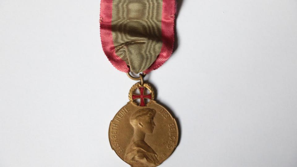 Avers de la médaille représentant Elisabeth, troisième reine des Belges, également connue comme la reine-infirmière. La médaille est ornée d'une croix rouge pour souligner le fait qu'elle soit dédiée au personnel médical.